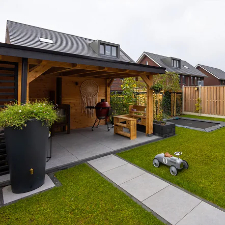 Tuin met overkapping en schutting